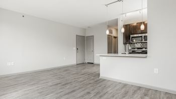 A spacious room with a kitchenette and a door leading to another room